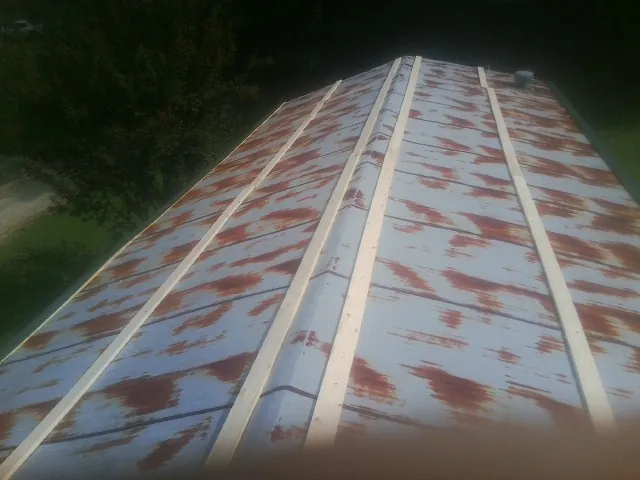Rusted metal roof panels with new wood purlins before replacement — Storm Damage Roof Repair in Little Orleans by Roofing Brothers