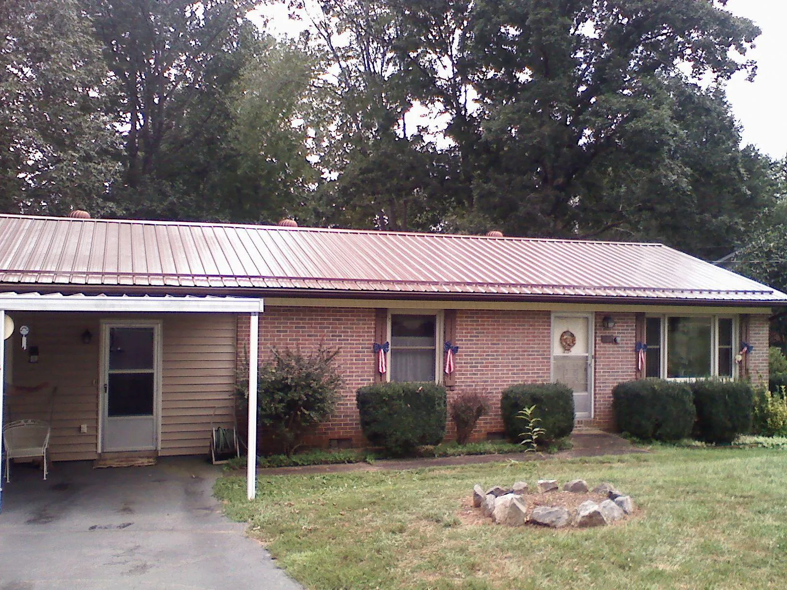 Bronze metal roof and carport on a brick ranch home — Roof Repair work by our crew in Little Orleans