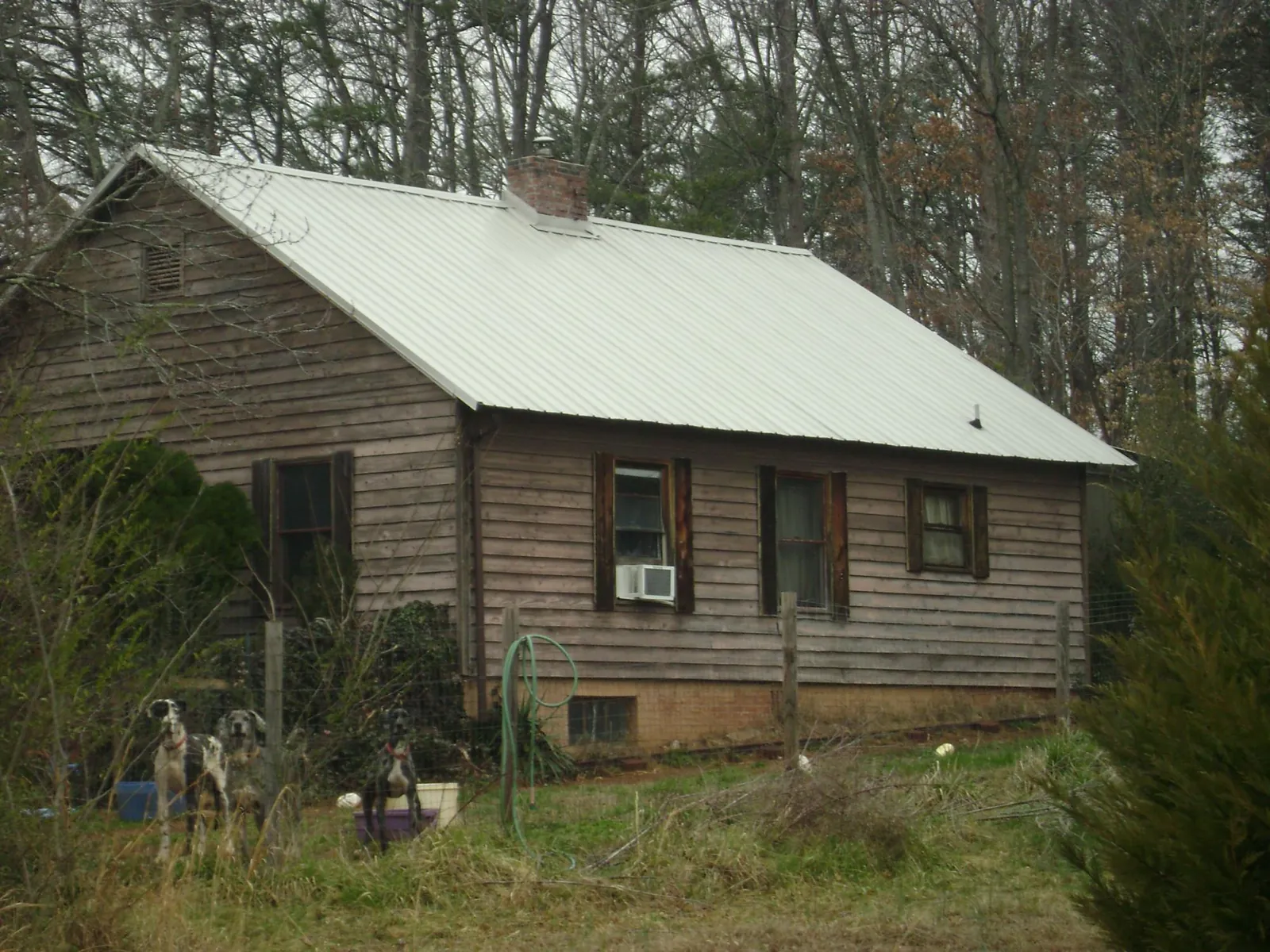 White metal roof on an old wood sided farmhouse, from a Metal Roof Installation job in Little Orleans